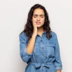 Woman with toothache needing tooth extraction - Trade Winds Dental